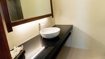A bathroom with a white sink, a mirror, and a towel rack.