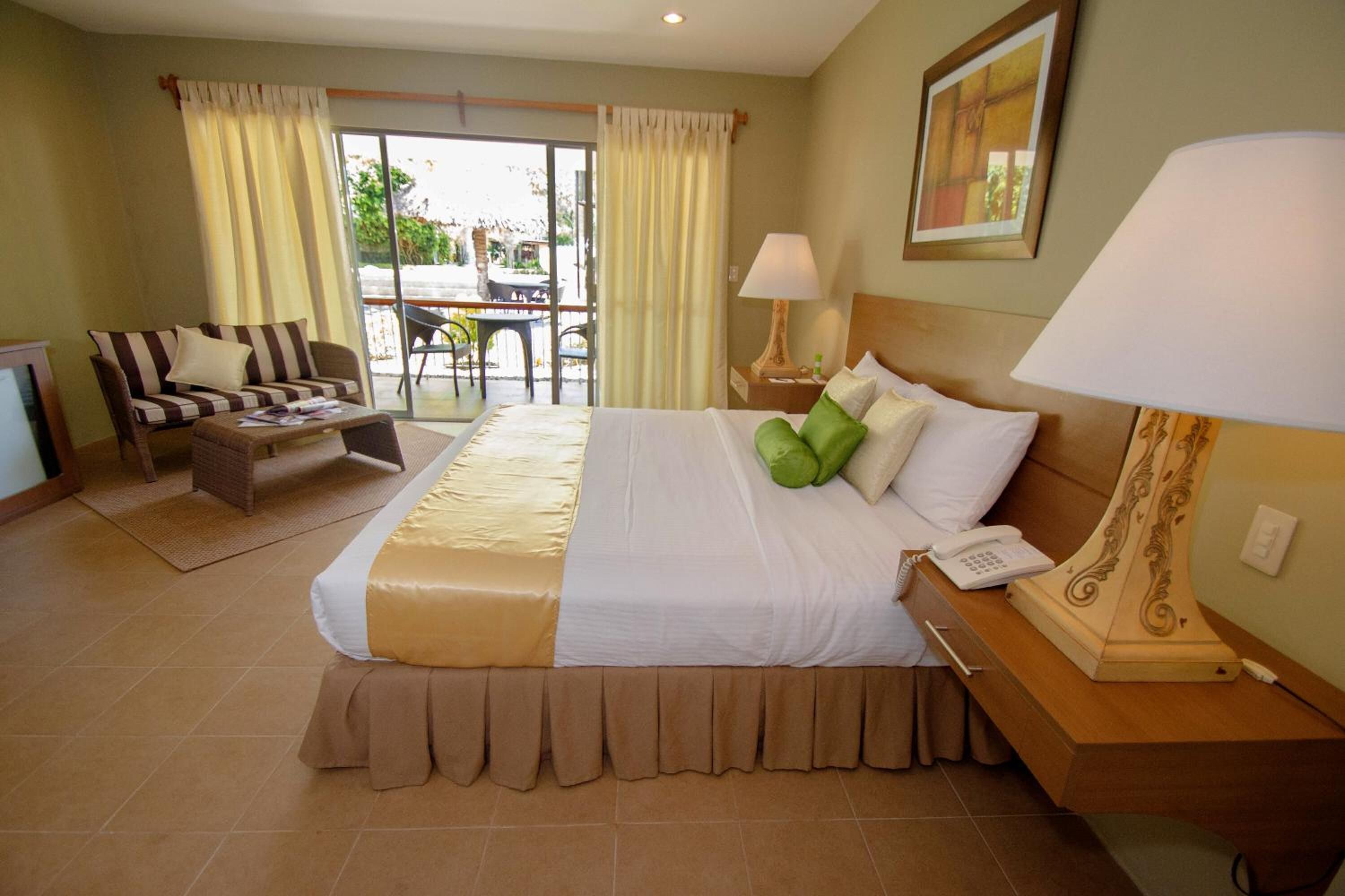 Une chambre d’hôtel avec un lit, un canapé, un bureau et une chaise.