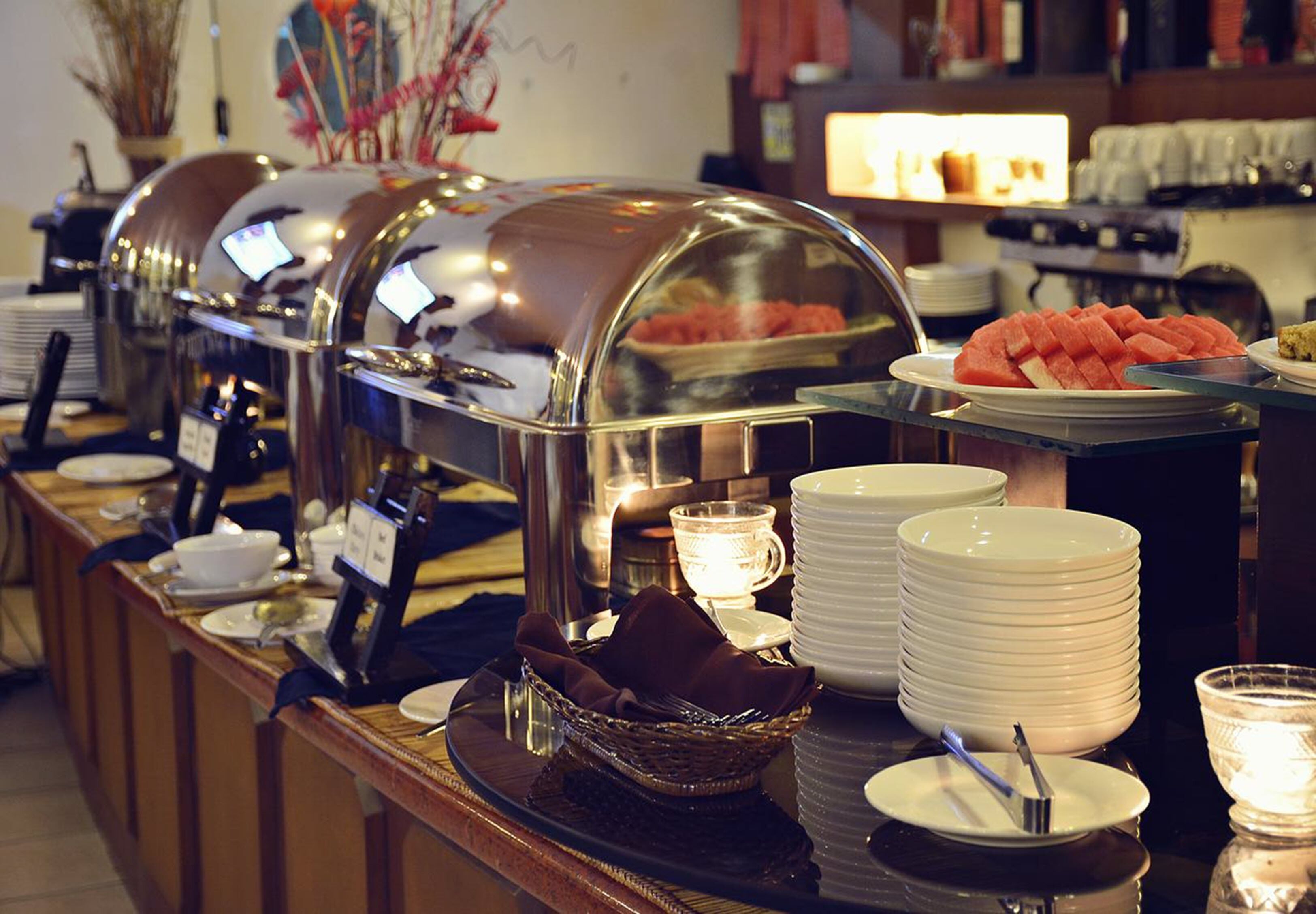 A buffet setup with various food items and serving utensils.