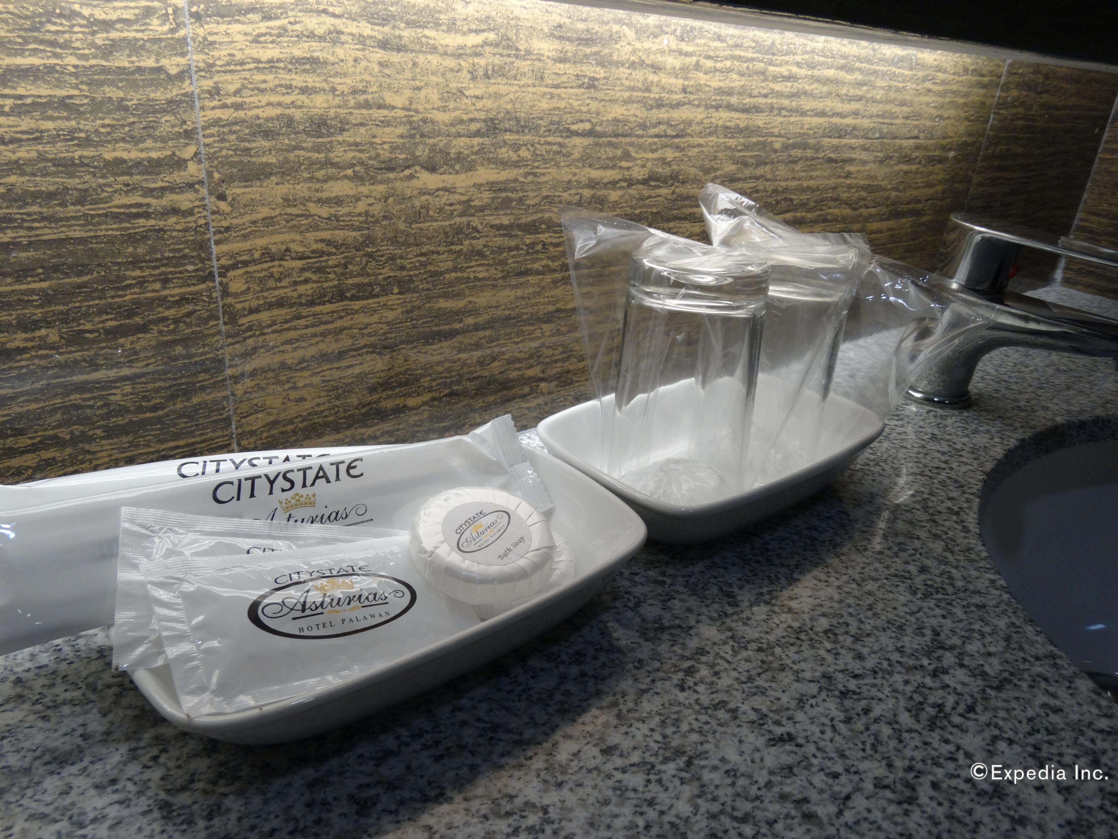 A bathroom sink with a granite countertop, a soap dispenser, and a bottle of hand soap.