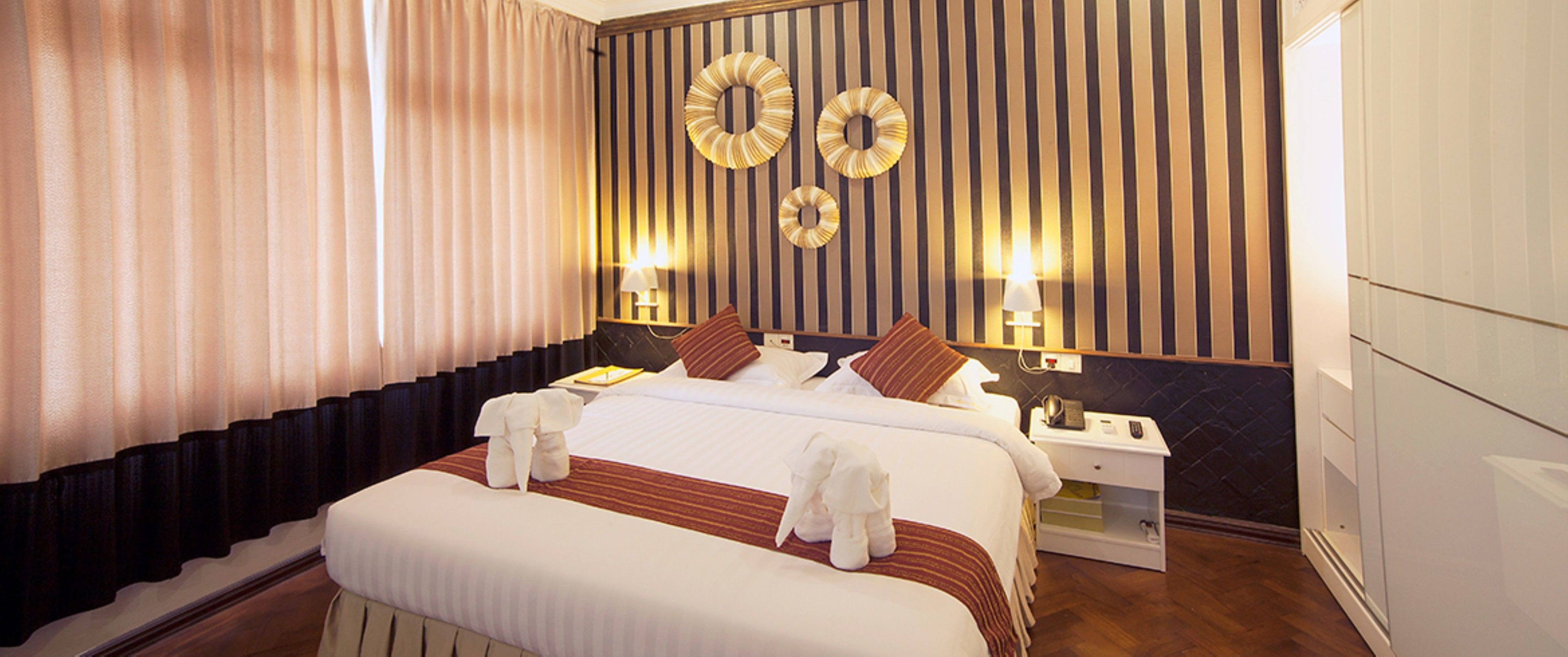 deluxe room | minibar, in-room safe, blackout curtains, iron/ironing board