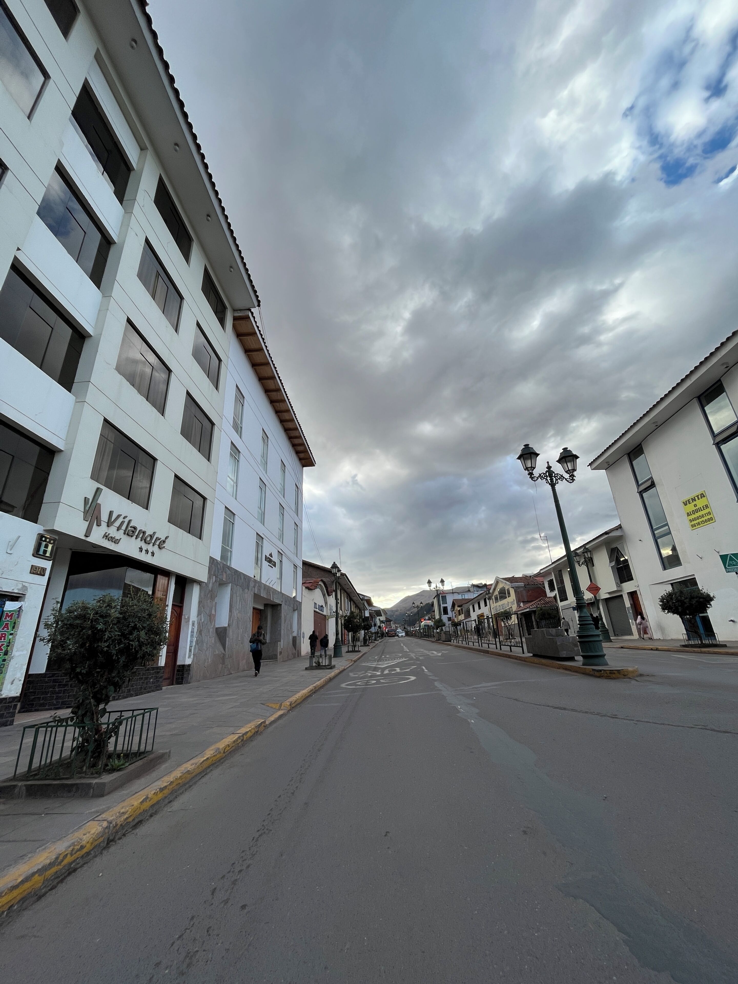 Une vue de rue avec un hôtel appelé « Vilandre » sur la gauche, une route dégagée et des immeubles dotés de balcons.
