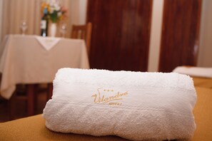 A neatly folded white towel with the inscription "Vilandra Hotel" on a wooden surface. - Hotel Vilandré (Cusco)