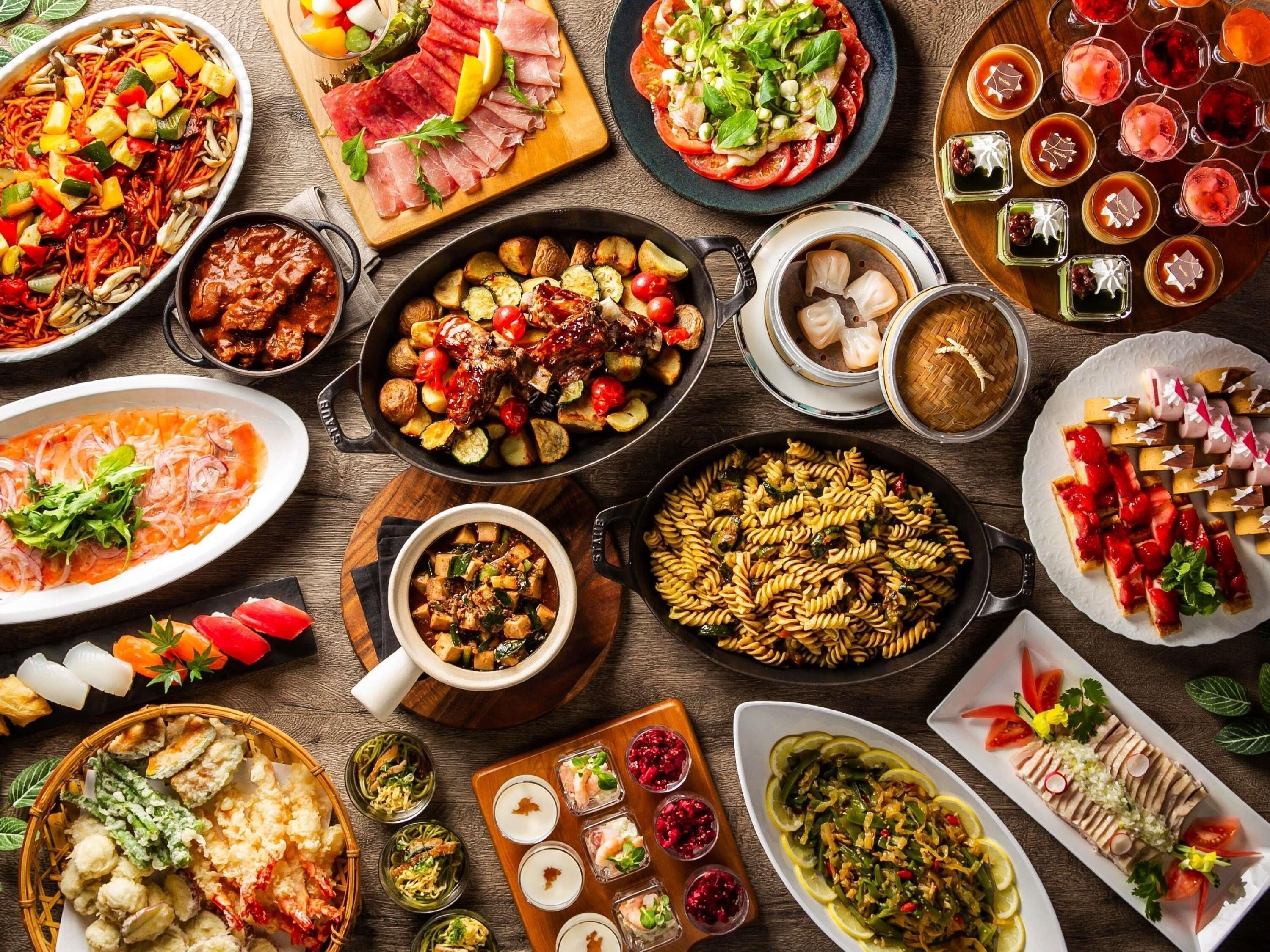 A variety of dishes and drinks on a wooden table.
