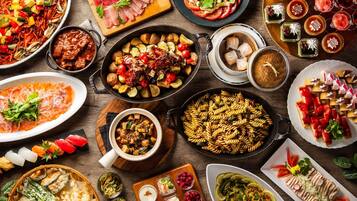 A variety of dishes and drinks on a wooden table.