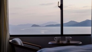 A room with a large window overlooking a calm sea and distant mountains. - Mercure Saga Karatsu Resort (Karatsu)