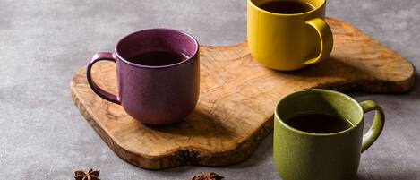 Tres tazas de cerámica sobre una tabla de madera.