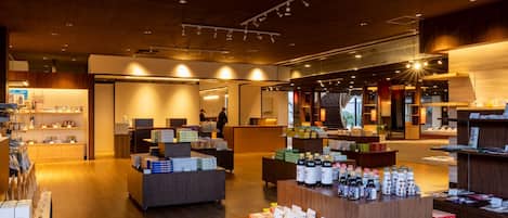 Una tienda minorista moderna con suelo de madera, varios mostradores de exhibición y una gran variedad de productos, incluyendo bebidas y alimentos envasados.