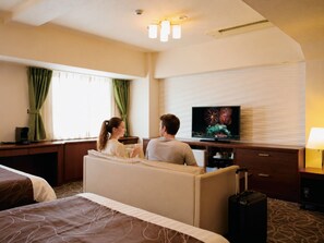 A hotel room with a bed, a TV, a desk, and a suitcase. - Hotel Plaza Osaka (Osaka)