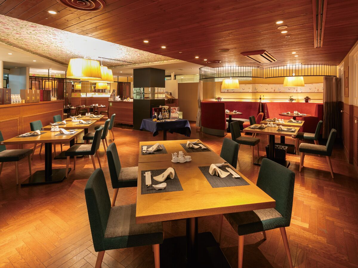 Un ristorante con tavoli e sedie in legno, un'area bar e un'atmosfera accogliente.