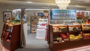 Una tienda con una gran variedad de productos envasados, incluyendo snacks y posiblemente artículos de regalo, exhibidos en estantes y mostradores.