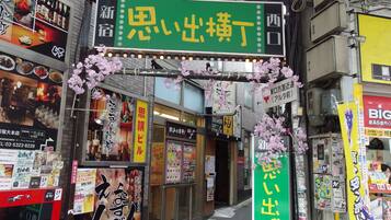 A street view with various signs and advertisements, including a prominent green sign with Japanese characters.