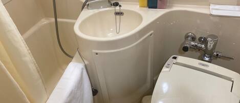 A bathroom with a sink, toilet, and a towel rack.