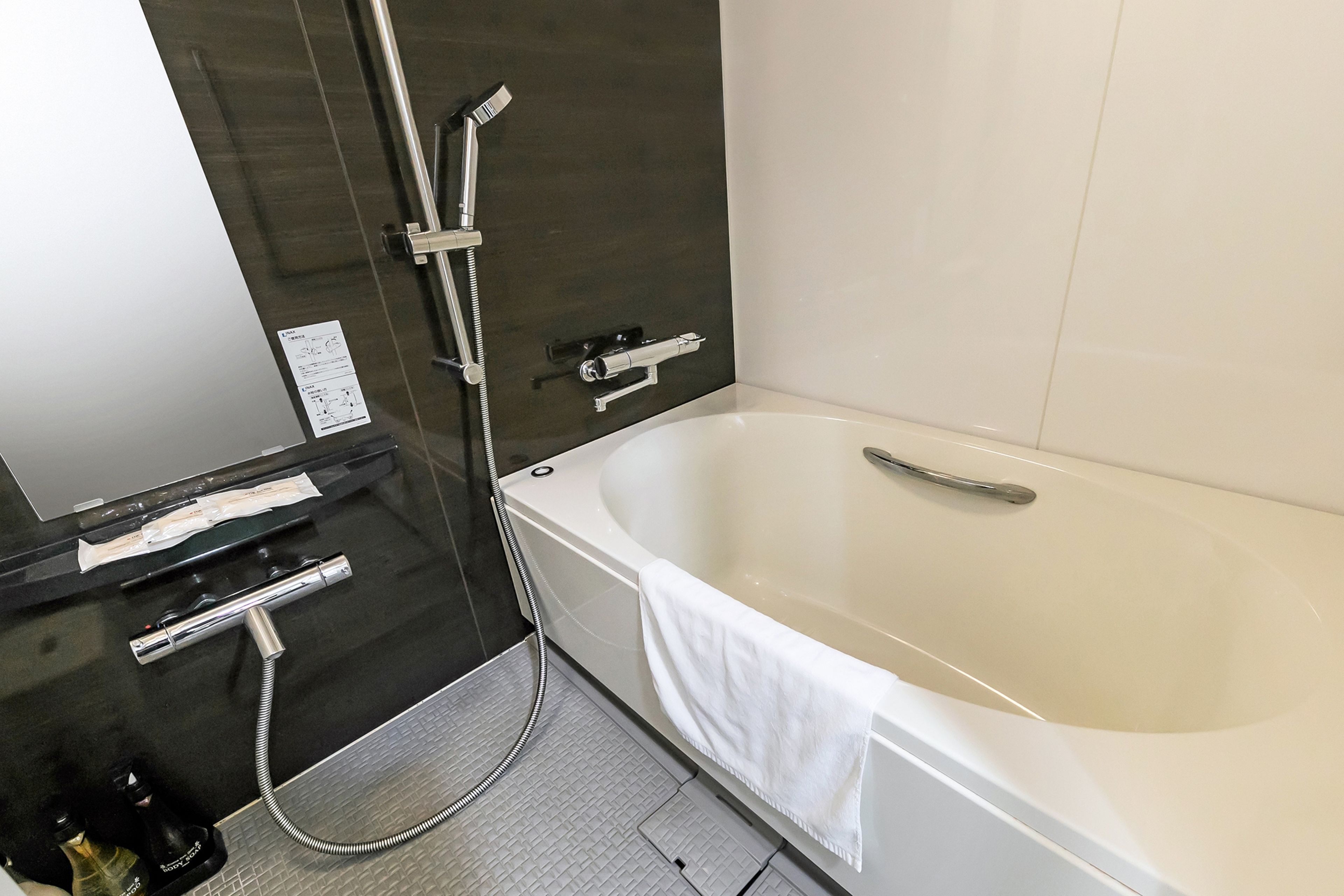 Un baño moderno con una bañera grande, ducha con cabezal de mano y un aspirador de mano.