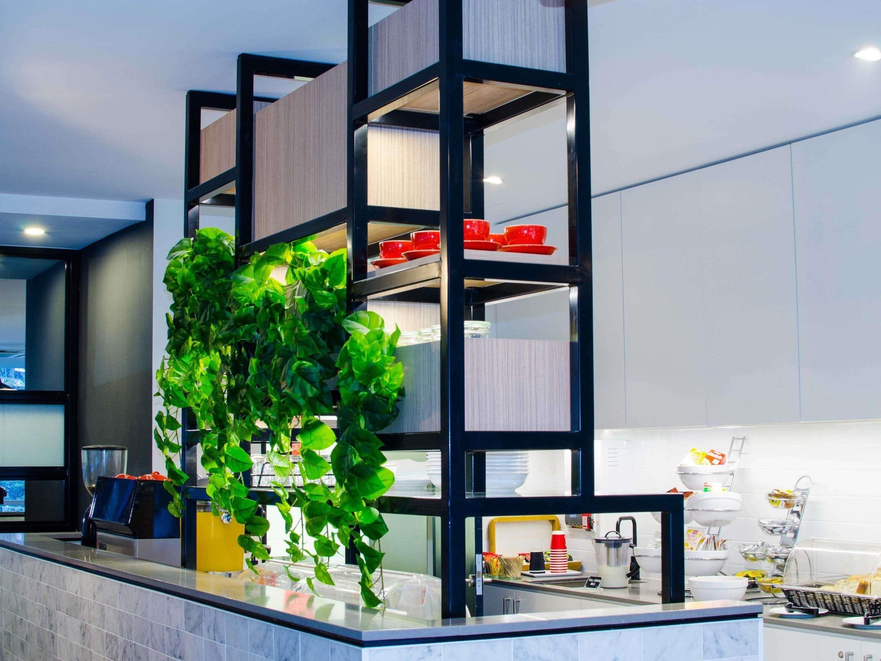 Una cocina moderna con una planta integrada, una cafetera y una barra para desayunos.
