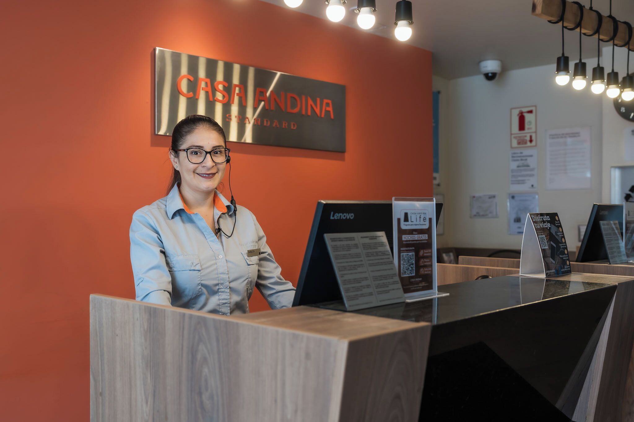 A reception desk with a sign reading "CASA ANDINA STANDARD" and a Lenovo computer.