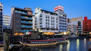 A multi-story building with a prominent red sign for a hotel.