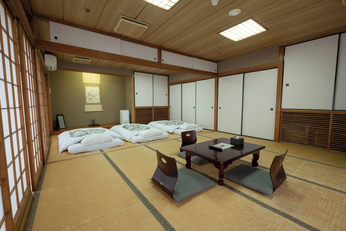 A traditional Japanese room with tatami flooring, a low table, and shoji screens.