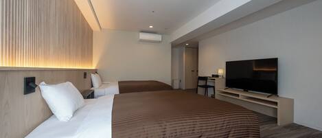 A modern hotel room with a large bed, a TV, and a desk area.