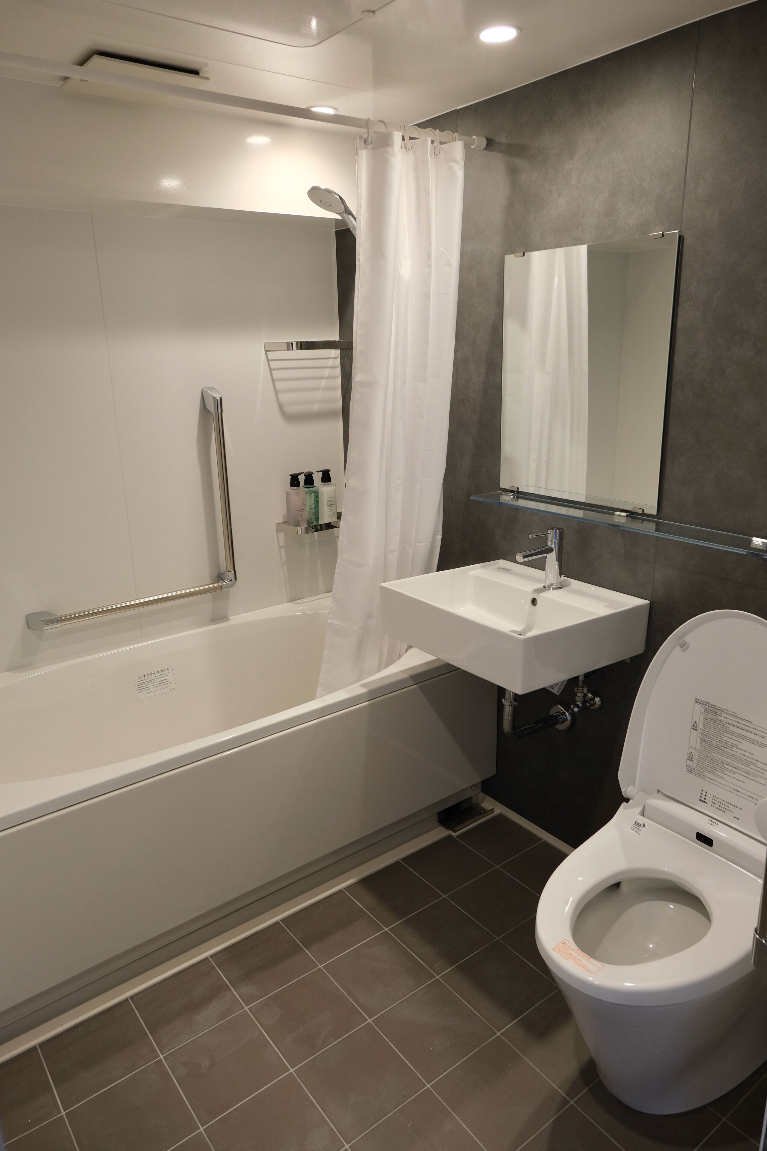 Ein modernes Badezimmer mit Badewanne, Waschbecken und Toilette.