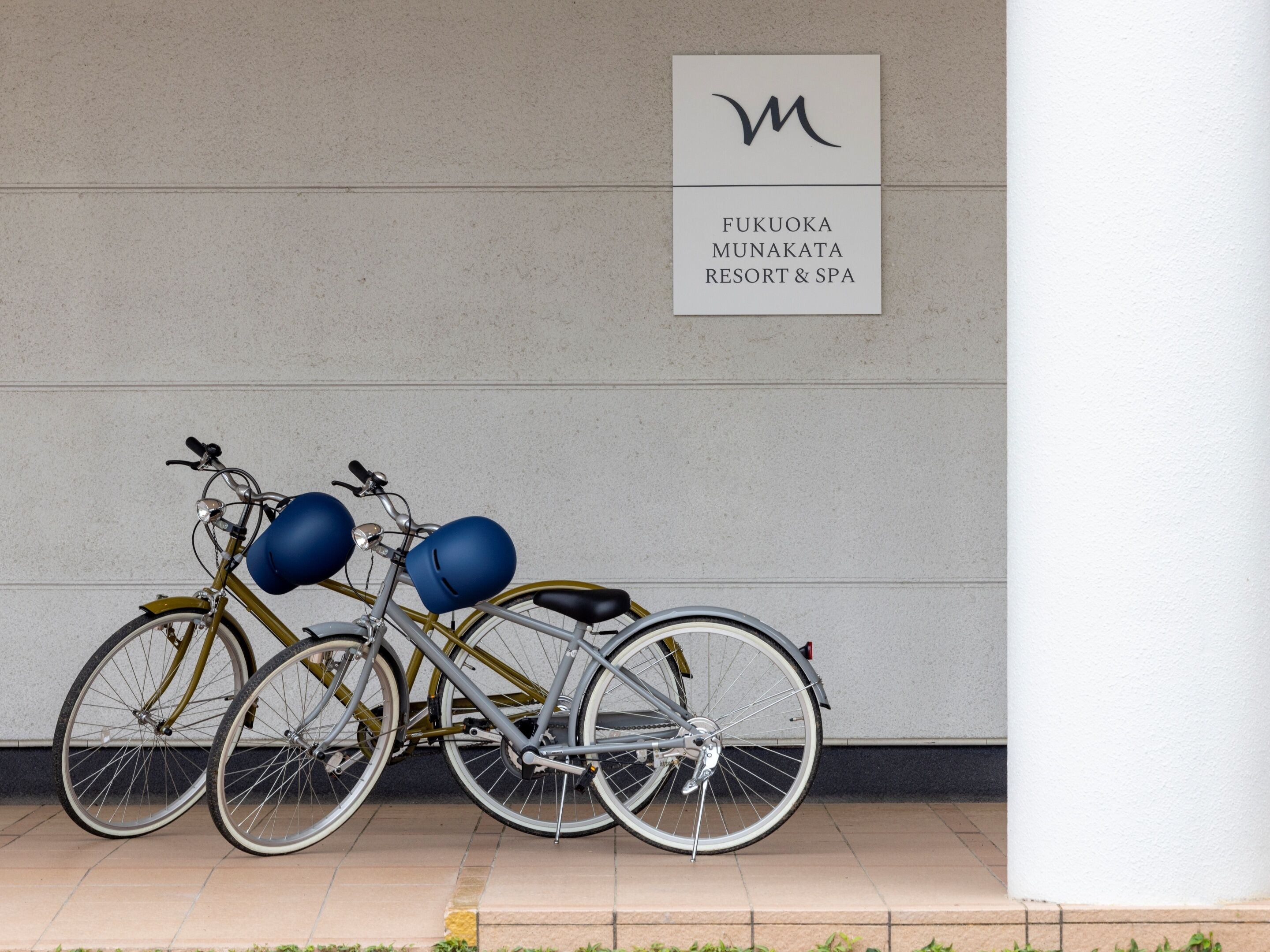 Una bicicleta estacionada frente a un cartel del Fukuoka Munakata Resort & Spa.
