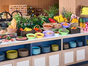 Un bufé con diversos alimentos, una variedad de tazones y platos.