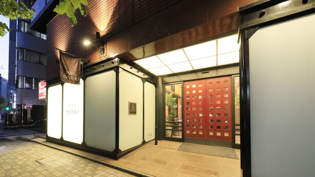 A hotel entrance with a tiled pavement, a red gate, and a sign for 'Hotel Saibo'. - Hotel Nihonbashi Saibo (Tokyo)