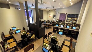 A modern restaurant with multiple tables and booths, equipped with computers and various amenities. - Hotel Nihonbashi Saibo (Tokyo)