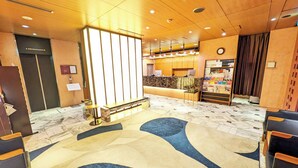 A hotel lobby with a reception desk, seating area, and a clock on the wall. - Hotel Nihonbashi Saibo (Tokyo)