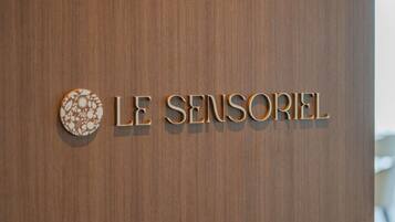 A wooden door with the text 'LE SENSORIEL' and a circular decorative element.