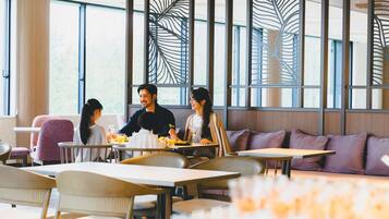 A modern dining area with tables and chairs, large windows, and decorative panels.