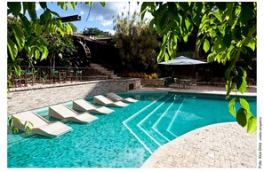 Una piscina al aire libre, tumbonas