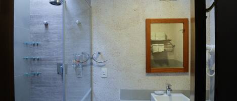 A modern bathroom with a glass shower enclosure, a sink, and a mirror.