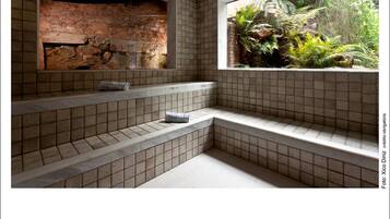 Relax in this stylish bathroom with a bench and garden view.