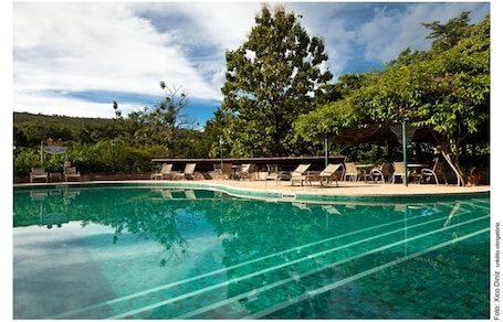 Una piscina al aire libre, sillones reclinables de piscina
