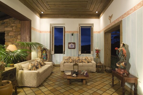 A cozy living room with two sofas, a coffee table, and a statue. - Hotel de Lençóis (Lençóis)