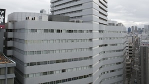 Een modern meerlaags gebouw met een opvallende hoekpartij en een plat dak.