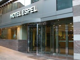 L’extérieur de l’hôtel EspeI présente un design moderne, avec une entrée imposante dotée de portes vitrées et une vue dégagée sur l’intérieur à travers les fenêtres.