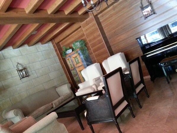 A room with a piano, a sofa, and a dining table with chairs. - Villa de Canfranc (Canfranc)