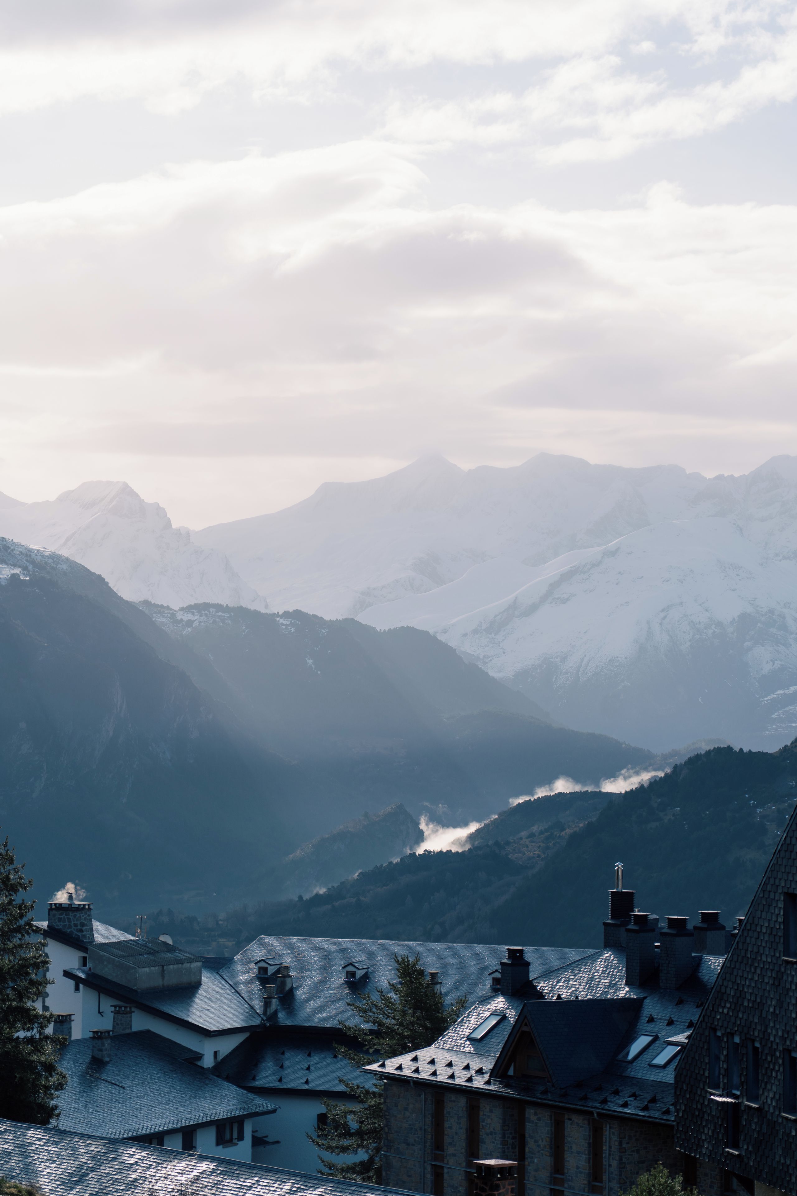 Eine Berglandschaft mit einem Tal und einer Ansammlung von Gebäuden mit schrägen Dächern.