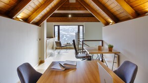 A modern interior with a wooden ceiling, a dining area with a table and chairs, and a view of a snowy landscape through large windows. - Snö Aragon Hills (Sallent de Gallego)
