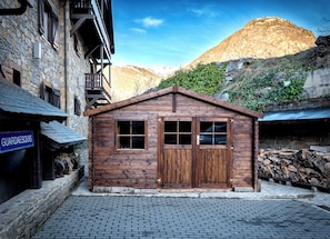 Una cabaña rústica de madera con fachada de piedra, puerta de madera y ventana.