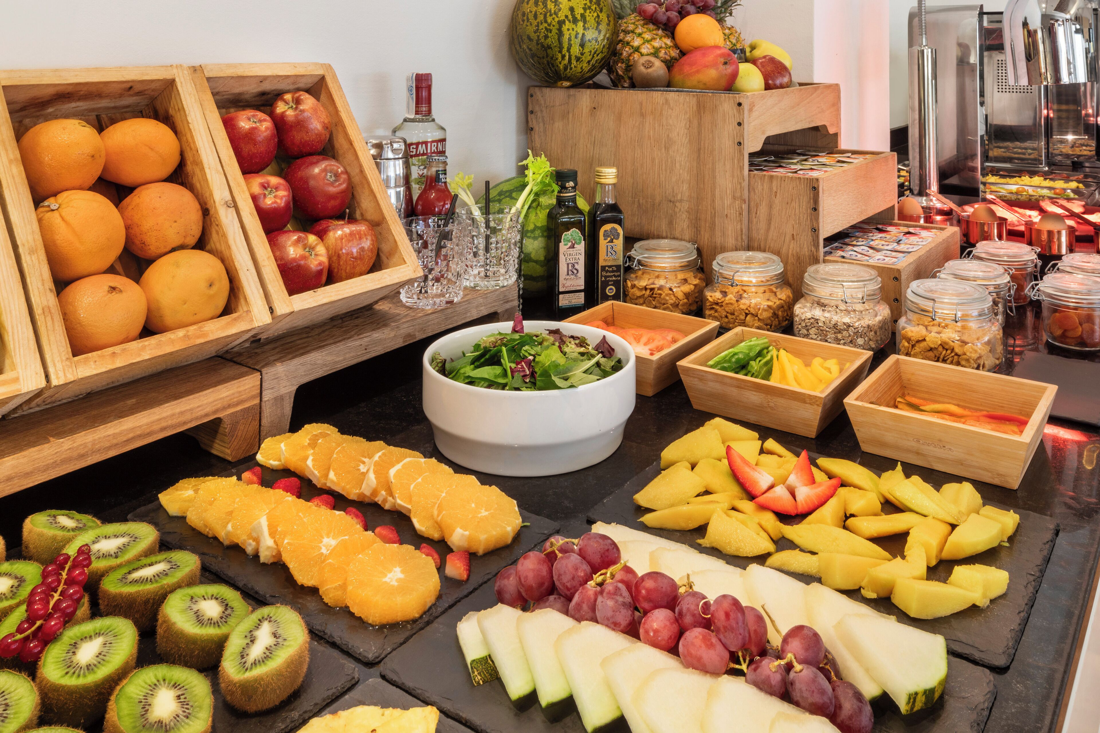 A buffet with various fruits, vegetables, and condiments.