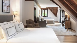 Un dormitorio con una cama grande, un sofá, una silla y un escritorio con una lámpara.