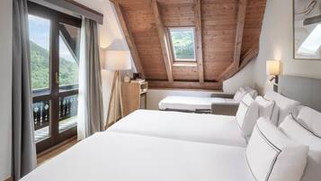 Een slaapkamer met een groot bed, een bureau en uitzicht op een berg door een raam.