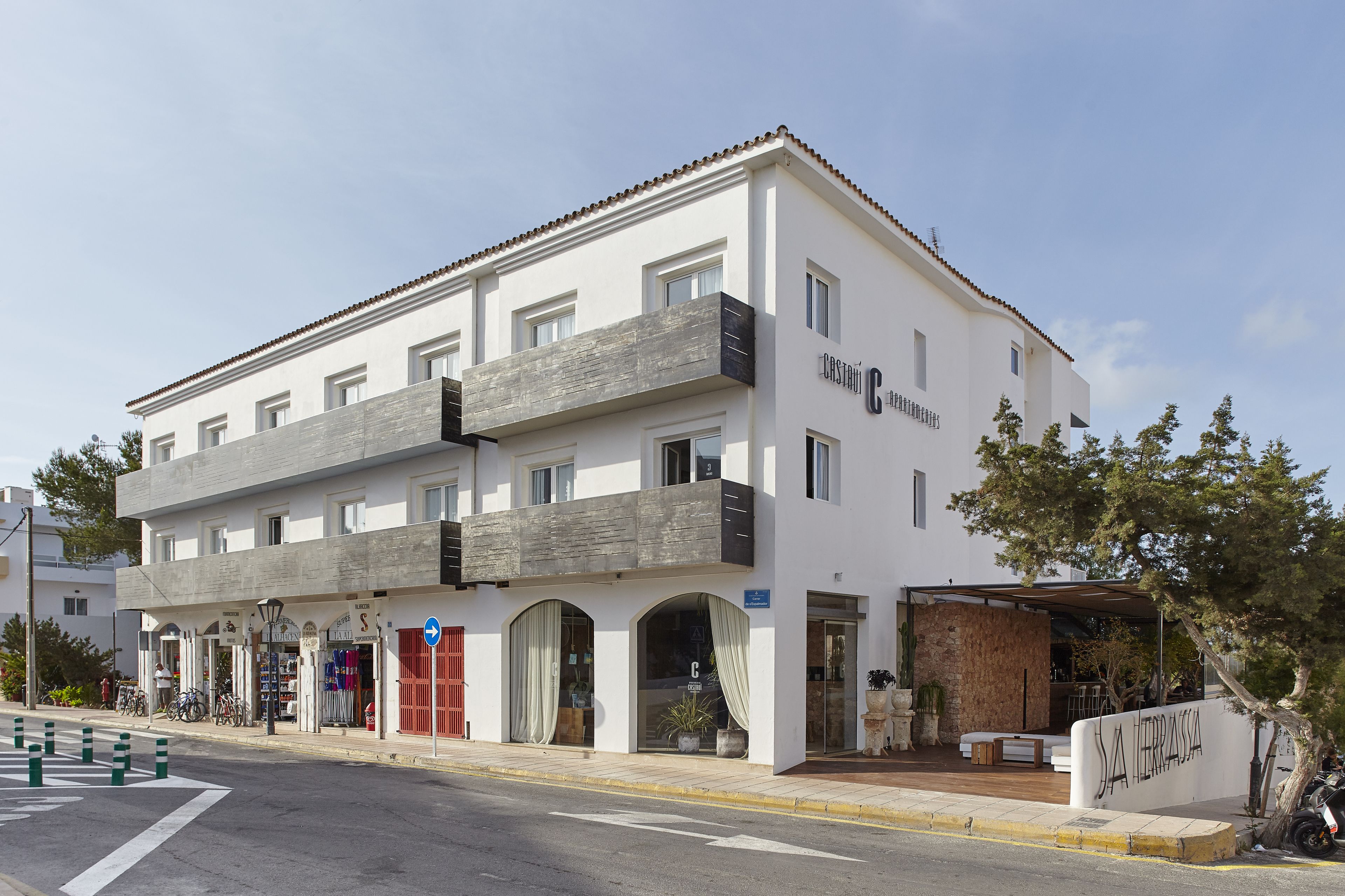 Un bâtiment moderne à la façade blanche, doté de nombreux balcons et d’une enseigne indiquant « Casa de la Terra ».