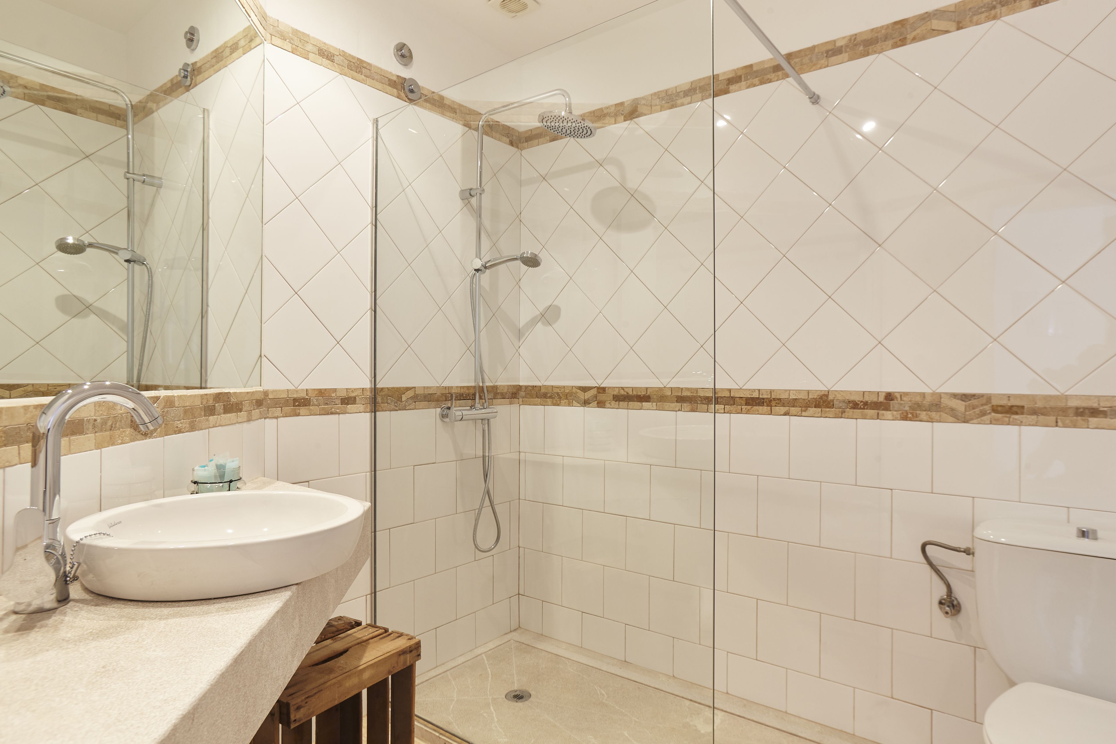 A modern bathroom with a glass-enclosed shower, a sink, and a toilet.