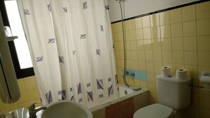 A bathroom with a bathtub, toilet, sink, and a shower. - Oasis D'or (Santanyi)
