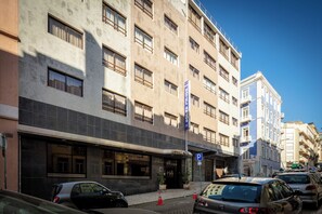 Ein mehrstöckiges Hotelgebäude mit Eingang und Parkschild.