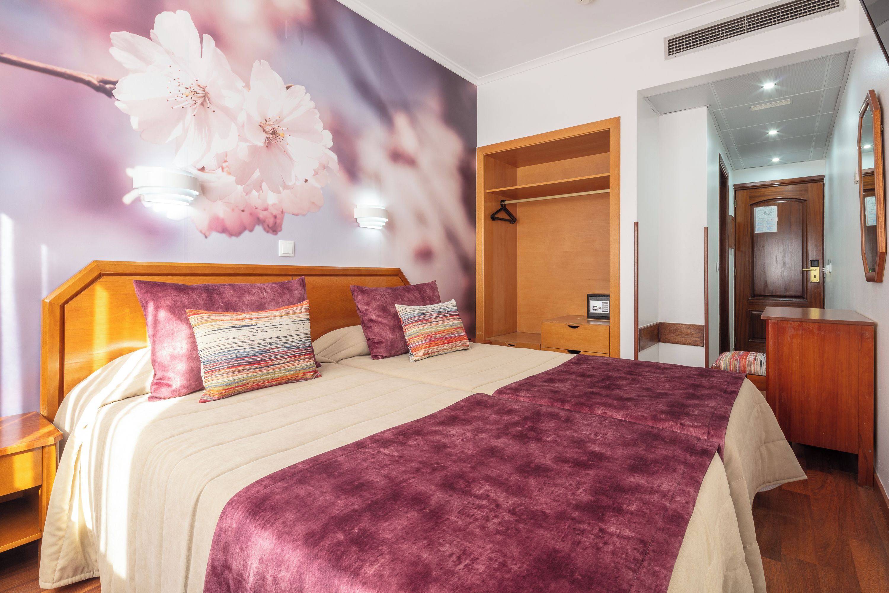 Ein Schlafzimmer mit einem großen Bett, einem Holzschrank und einem Spiegel an der Wand.